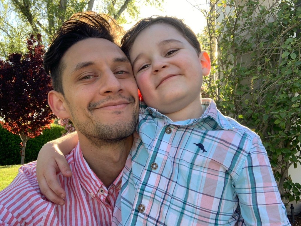 Aziz with his father outdoors, smiling together