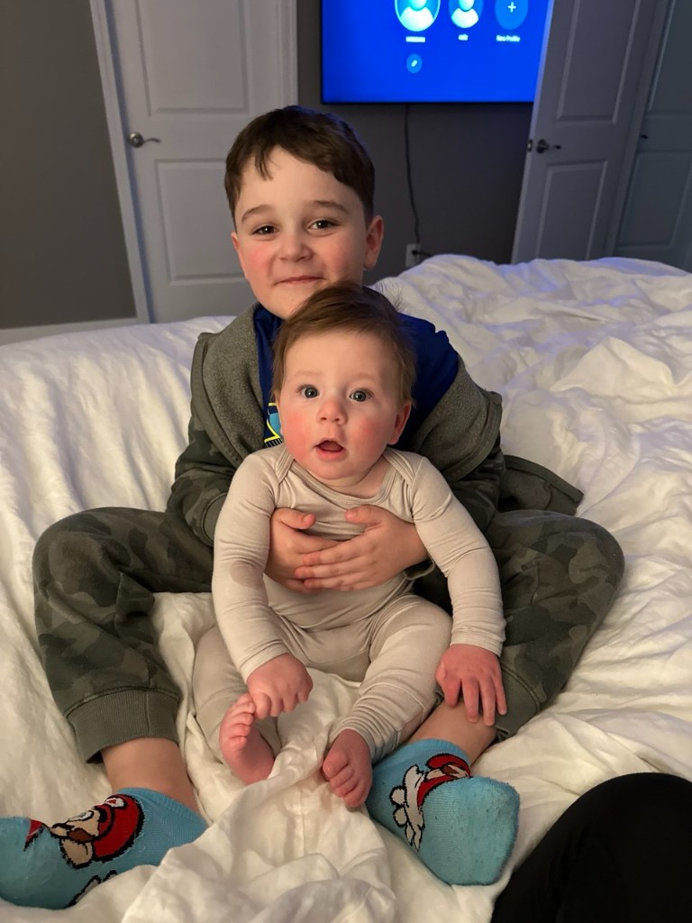 Aziz sitting on a bed with his younger brother