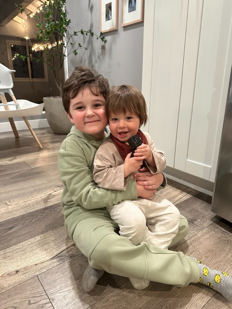 Aziz holding his toddler brother at home