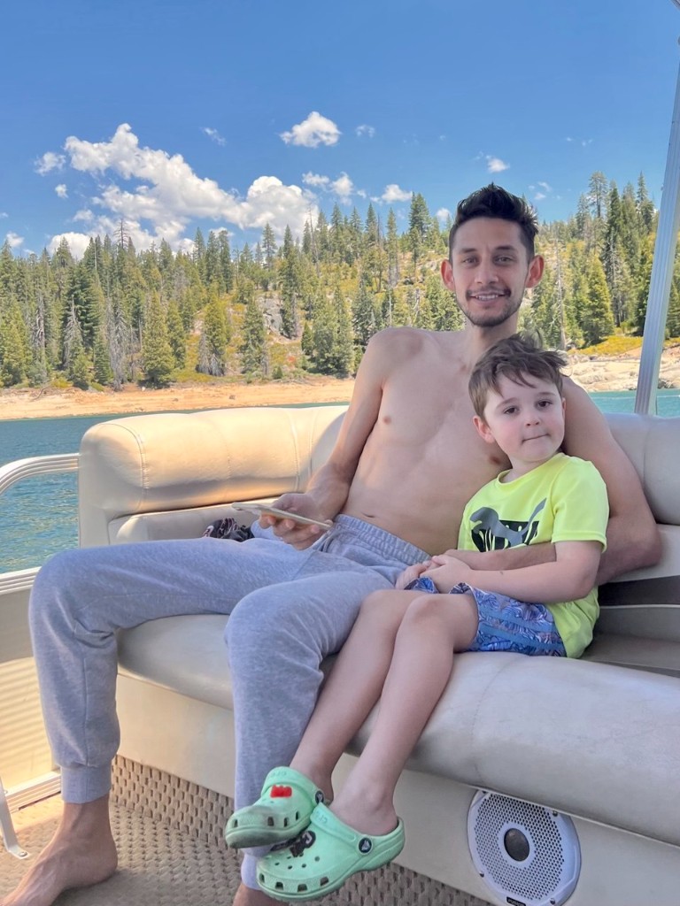Aziz with his father sitting together on a boat